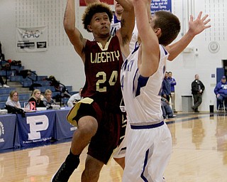 Liberty's Capone Haywood (24) drives to the hoop while being defended by Poland's Billy Orr (24) during the first half of Friday nights matchup at Poland Seminary High School.  Dustin Livesay  |  The Vindicator  12/3/16  Poland