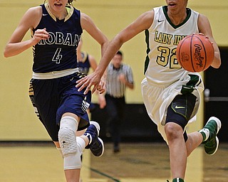 YOUNGSTOWN, OHIO - DECEMBER 7, 2016: Simone Comer #32 of Ursuline drives on Nicole Roberts #4 of Ursuline during the first half of their game Wednesday night at Ursuline High School. DAVID DERMER | THE VINDICATOR