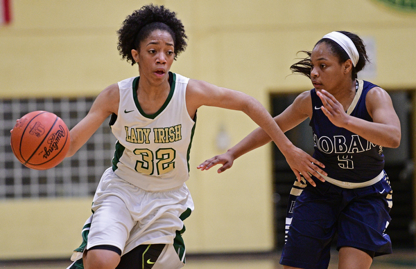 YOUNGSTOWN, OHIO - DECEMBER 7, 2016: Simone Comer #32 of Ursuline drives on Leah Hall #5 of Hoban during the first half of their game Wednesday night at Ursuline High School. DAVID DERMER | THE VINDICATOR