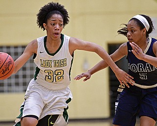 YOUNGSTOWN, OHIO - DECEMBER 7, 2016: Simone Comer #32 of Ursuline drives on Leah Hall #5 of Hoban during the first half of their game Wednesday night at Ursuline High School. DAVID DERMER | THE VINDICATOR