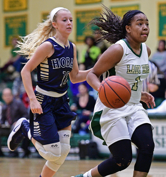 YOUNGSTOWN, OHIO - DECEMBER 7, 2016: Dayshanette Harris #1 of Ursuline looks to the basket while being chased from behind by Rachel Chessar #10 of Hoban during the first half of their game Wednesday night at Ursuline High School. DAVID DERMER | THE VINDICATOR