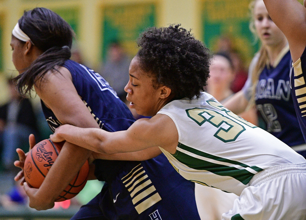 YOUNGSTOWN, OHIO - DECEMBER 7, 2016: Simone Comer #32 of Ursuline grabs the arm of Lonasia Brewer #43 of Hoban after she took the ball away from her during the first half of their game Wednesday night at Ursuline High School. DAVID DERMER | THE VINDICATOR