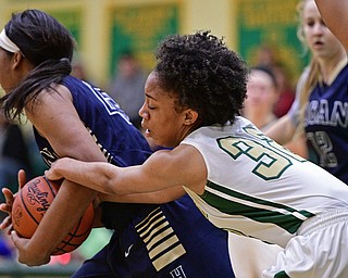 YOUNGSTOWN, OHIO - DECEMBER 7, 2016: Simone Comer #32 of Ursuline grabs the arm of Lonasia Brewer #43 of Hoban after she took the ball away from her during the first half of their game Wednesday night at Ursuline High School. DAVID DERMER | THE VINDICATOR