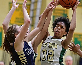 YOUNGSTOWN, OHIO - DECEMBER 7, 2016: Simone Comer #32 of Ursuline attempts to put up a shot under the basket while being pressured by Emma Tecca #3 of Hoban during the second half of their game Wednesday night at Ursuline High School. DAVID DERMER | THE VINDICATOR