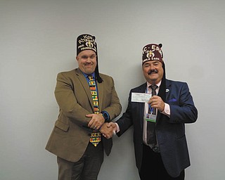 SPECIAL TO THE VINDICATOR
Youngstown Shrine Club President Lou Garland, left, presented a donation of $10,000 from the club to Bob Lee, Shriners Hospitals for Children board of governors chairman. The donation is earmarked for the new EOS micro dose imaging system planned for the Erie facility. The Erie hospital is one of 22 Shriner hospitals throughout North America that provides family-oriented care for children with orthopedic conditions, spinal cord injuries and related treatments. This system uses 85 percent less radiation than most X-rays, and images can be taken in natural positions such as standing or sitting. For information about the club or donating to the imaging system, call 330-549-3857.