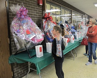 Neighbors | Alexis Bartolomucci.Guests put their tickets in the basket raffle prizes during the Holiday Shop on Nov. 5 at Poland Seminary High School.