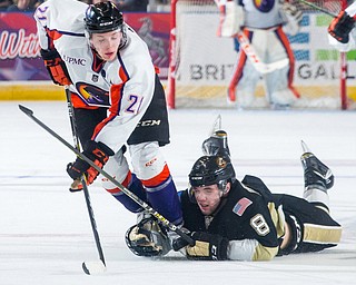 Scott R. Galvin | Vindicator.Youngstown Phantoms forward Tommy Apap (21) gets tripped up by Muskegon Lumberjacks defenseman Zach Berzolla (8) while skating for a loose puck during overtime at the Covelli Centre on Dec. 8, 2016. The Phantoms lost 4-3 in overtime.
