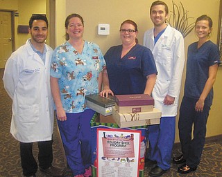 Ankle & Foot Care Centers launched its 19th annual holiday shoe and sock drive on Dec. 1. The group is collecting new or like new shoes and new socks until Jan. 6 at all 20 offices in Mahoning, Trumbull, Columbiana, Stark, Ashtabula and Portage counties and Mercer County in Pennsylvania. Doctors and staff of Ankle & Foot Care Centers, from left, are Dr. Frank Luckino, Amy Assion, Cara Adkins, Dr. Zachary Flynn and Julia Sorg. 
SPECIAL TO THE VINDICATOR