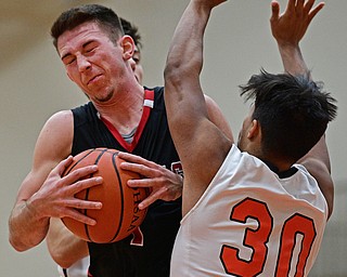 HOWLAND, OHIO - DECEMBER 9, 2016: Jake Cummings #1 of Canfield goes to the basket while bumping Deon Patterson #30 of Howland during the first half of their game Friday night at Howland High School. DAVID DERMER | THE VINDICATOR