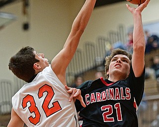 HOWLAND, OHIO - DECEMBER 9, 2016: Zach Tinkey #21 of Canfield puts up a shot while Nolan Brill #32 of Howland goes for the block during the first half of their game Friday night at Howland High School. DAVID DERMER | THE VINDICATOR