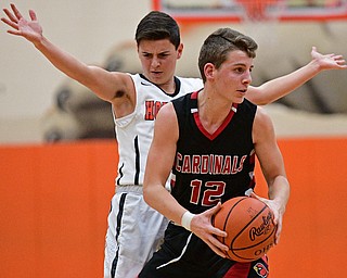HOWLAND, OHIO - DECEMBER 9, 2016: Ethan Kalina #12 of Canfield looks to pass the ball after bumping into Frank Rappach #3 of Howland during the first half of their game Friday night at Howland High School. DAVID DERMER | THE VINDICATOR