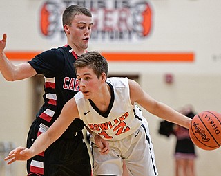 HOWLAND, OHIO - DECEMBER 9, 2016: Michael Massucci #12 of Howland stumbles while being bumped by Brandon McFall #4 of Canfield during the second half of their game Friday night at Howland High School. DAVID DERMER | THE VINDICATOR