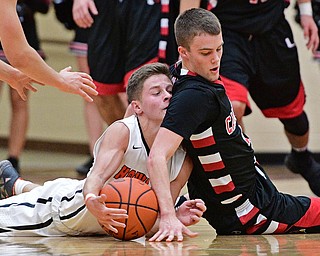HOWLAND, OHIO - DECEMBER 9, 2016: Connor Tamarkin #13 of Howland collides with Brandon McFall #4 of Canfield on the floor while both battle for a loss ball during the second half of their game Friday night at Howland High School. DAVID DERMER | THE VINDICATOR
