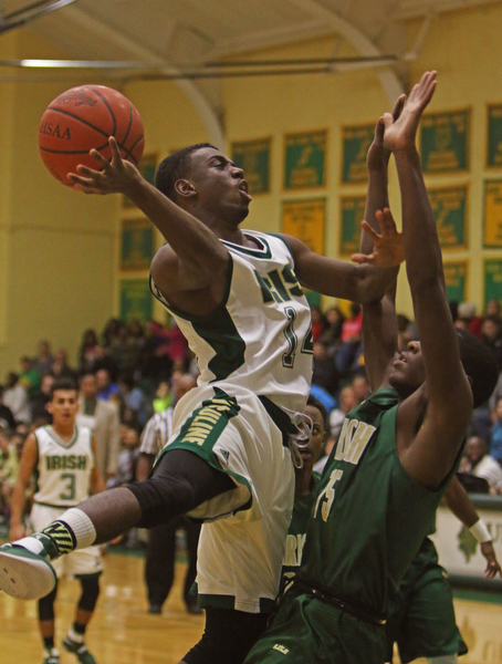 Ursuline's Dakota Hobbs (14) goes up for a layup while being defended by Akron St. Vincent-St. Mary's Lundon McDay (15) during the first half of Friday nights matchup at Ursuline High School in Youngstown.   Dustin Livesay  |  The Vindicator