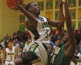 Ursuline's Dakota Hobbs (14) goes up for a layup while being defended by Akron St. Vincent-St. Mary's Lundon McDay (15) during the first half of Friday nights matchup at Ursuline High School in Youngstown.   Dustin Livesay  |  The Vindicator