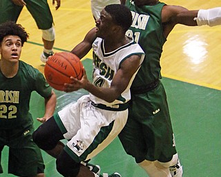 Ursuline's Dakota Hobbs (14) goes up for a layup while being defended by Akron St. Vincent-St. Mary's Justin Sampson (21) during the first half of Friday nights matchup at Ursuline High School in Youngstown.   Dustin Livesay  |  The Vindicator