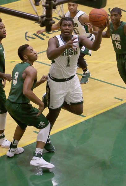 Ursuline's Anthony Howell (1) puts up a layup over Akron St. Vincent-St. Mary's DeAmonte' King (3) during the first half of Friday nights matchup at Ursuline High School in Youngstown.   Dustin Livesay  |  The Vindicator