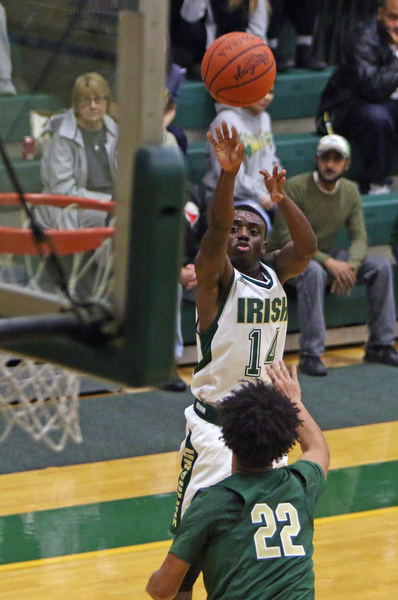 Ursuline's Dakota Hobbs (14) puts up a jump shot over Akron St. Vincent-St. Mary's Malik Lewis (22) during the first half of Friday nights matchup at Ursuline High School in Youngstown.   Dustin Livesay  |  The Vindicator