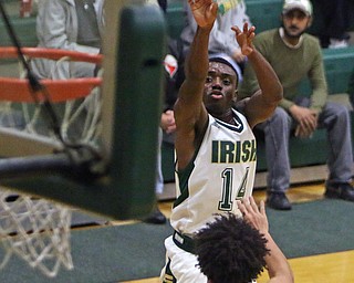 Ursuline's Dakota Hobbs (14) puts up a jump shot over Akron St. Vincent-St. Mary's Malik Lewis (22) during the first half of Friday nights matchup at Ursuline High School in Youngstown.   Dustin Livesay  |  The Vindicator