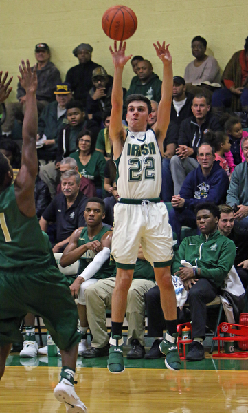 Ursuline's Vince Venzeio (22) puts up a 3-pointer while being defended by Akron's St.- Vincent St. Mary's Scott Walter (1) during the first half of Friday nights matchup at Ursuline High School in Youngstown.   Dustin Livesay  |  The Vindicator