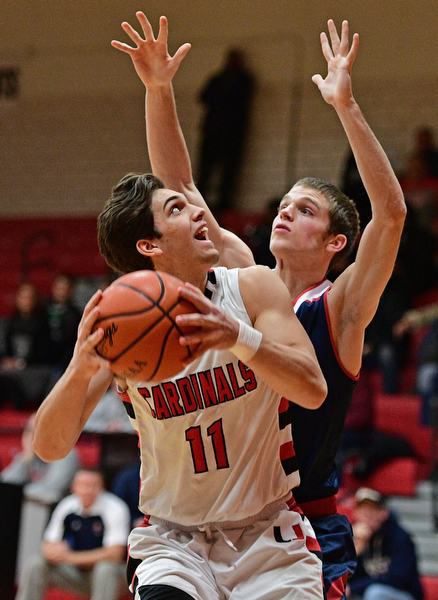 CANFIELD, OHIO - DECEMBER 12, 2016: Spencer Woolley #11 of Canfield looks to the basket while Dylan Beany #21 of Fitch goes for the block during the first half of their game Tuesday night at Canfield High School. DAVID DERMER | THE VINDICATOR