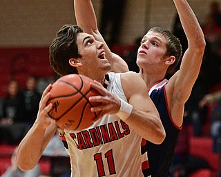 CANFIELD, OHIO - DECEMBER 12, 2016: Spencer Woolley #11 of Canfield looks to the basket while Dylan Beany #21 of Fitch goes for the block during the first half of their game Tuesday night at Canfield High School. DAVID DERMER | THE VINDICATOR