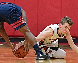 CANFIELD, OHIO - DECEMBER 12, 2016: Ethan Kalina #12 of Canfield attempts to rip the ball from the grasp of Jakari Lumsden #24 of Fitch after Lumsen lost control of the ball during the second half of their game Tuesday night at Canfield High School. DAVID DERMER | THE VINDICATOR