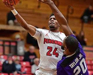 YOUNGSTOWN, OHIO - DECEMBER 13, 2016: Cameron Morse #24 of YSU goes to the basket while being pressured by Maurice Taylor Jr. #20 of Niagara during the first half of their game Wednesday night at the Beeghly Center. DAVID DERMER | THE VINDICATOR