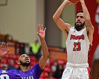 YOUNGSTOWN, OHIO - DECEMBER 13, 2016: Francisco Santiago #23 of YSU puts ups  three point shot while Kahlil Dukes #10 of Niagara looks up during the first half of their game Wednesday night at the Beeghly Center. DAVID DERMER | THE VINDICATOR