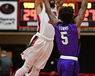 YOUNGSTOWN, OHIO - DECEMBER 13, 2016: Francisco Santiago #23 of YSU passes the ball while flying through the air while bing pressured by James Towns #5 of Niagara during the first half of their game Wednesday night at the Beeghly Center. DAVID DERMER | THE VINDICATOR