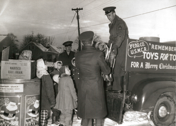 A big load of usable toys was ready and waiting for Marine reservists when they arrived in Struthers to pick up contributions in the current Toys for Tots Drive. Loading the toys aboard a Third Engineer Co. truck are Sgt. G. W. Osmudsen(back to camera) and Sgt. Ray V. McBride as Capt. George R. Schremp Jr. and neighborhood children "boss" the operation.