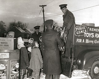 A big load of usable toys was ready and waiting for Marine reservists when they arrived in Struthers to pick up contributions in the current Toys for Tots Drive. Loading the toys aboard a Third Engineer Co. truck are Sgt. G. W. Osmudsen(back to camera) and Sgt. Ray V. McBride as Capt. George R. Schremp Jr. and neighborhood children "boss" the operation.