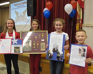 Neighbors | Alexis Bartolomucci.Fourth-grade students from Market Street Elementary School held up their projects from their .Veterans Day presentations on Nov. 11. Pictured are, from left, Alex Ward, Megan Faubel, Haley Eynon and Cameron Keffer.