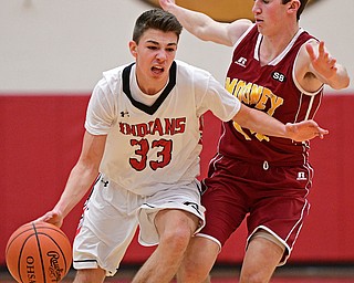 GIRARD, OHIO - DECEMBER 16, 2016: Austin O'Hara #33 of Girard drives on Pat Brennan #14 of Mooney during the first half of their game Friday night at Girard High School. DAVID DERMER | THE VINDICATOR