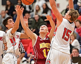 GIRARD, OHIO - DECEMBER 16, 2016: John Mikos #12 of Mooney reaches for the basketball while being tightly guarded by Austin Clausell #2 and Mark Waid #15 of Girard during the first half of their game Friday night at Girard High School. DAVID DERMER | THE VINDICATOR