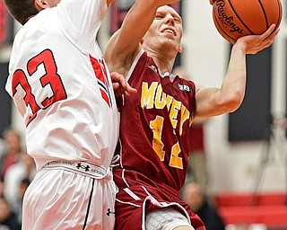 GIRARD, OHIO - DECEMBER 16, 2016: John Mikos #12 of Mooney goes to the basket while Austin O'Hara #33 of Girard goes for the block during the first half of their game Friday night at Girard High School. DAVID DERMER | THE VINDICATOR