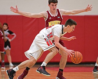 GIRARD, OHIO - DECEMBER 16, 2016: Austin O'Hara #33 of Girard dribbles while being cut off by Pat Brennan #14 of Mooney during the first half of their game Friday night at Girard High School. DAVID DERMER | THE VINDICATOR