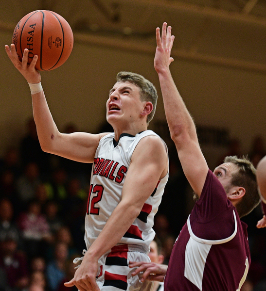 CANFIELD, OHIO - DECEMBER 20, 2016: Ethan Kalina #12 of Canfield goes to the basket while being pressured by John Ryan #1 of Boardman during the second half of their game Tuesday night at Canfield High School. DAVID DERMER | THE VINDICATOR