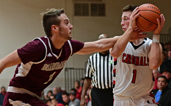 CANFIELD, OHIO - DECEMBER 20, 2016: Jake Cummings #1 of Canfield controls the ball while John Ryan #1 of Boardman reaches for it during the second half of their game Tuesday night at Canfield High School. DAVID DERMER | THE VINDICATOR