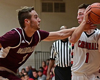 CANFIELD, OHIO - DECEMBER 20, 2016: Jake Cummings #1 of Canfield controls the ball while John Ryan #1 of Boardman reaches for it during the second half of their game Tuesday night at Canfield High School. DAVID DERMER | THE VINDICATOR