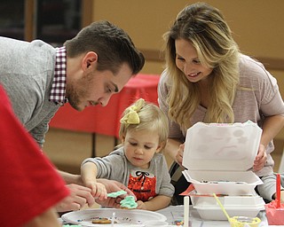 Ryan Pavlak(left) and his wife, Jennifer, help their daughter Penelope(2) decorate her cookies while making Cookies for Santa at Boardman Park's Lariccia Community Center in Boardman Park's Lariccia Community Center on Wednesday, Dec. 21, 2016...(Nikos Frazier | The Vindicator)..