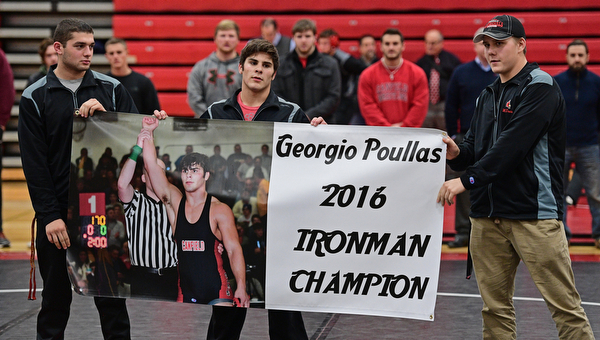CANFIELD, OHIO - DECEMBER 21, 2016: Canfield wrestler Georgio Poullas of Canfield is presented with a banner celebrating his Ironman wrestling tournament championship, Wednesday evening at Canfield High School. DAVID DERMER | THE VINDICATOR