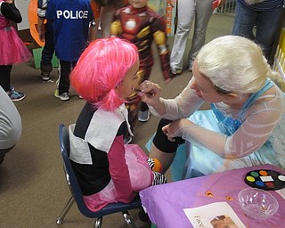 Neighbors | Alexis Bartolomucci.Abbey Loree paints a ghost on one of the children's face during the Fall Harvest Party at Hitchcock Woods Learning Center on Oct. 27.