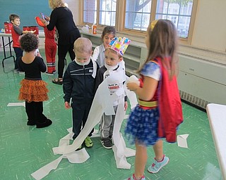 Neighbors | Alexis Bartolomucci.The girls wrapped the boys up in toilet paper to make them mummies during the Halloween science activities on Oct. 31 at Poland North Preschool.