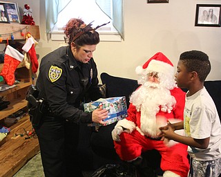 William D. Lewis The Vindicator YPD Community Police offocer Shawna-Cie Ott presents a gift to Jayden Mack, 7, in his West side Youngstown home Dec 22, 2016. His was one of several homes where community police officers donated and delivered Christmas gifts.