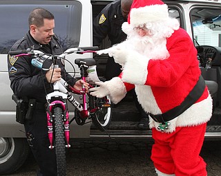 William D. Lewis The Vindicator YPD Community Police officer Joe Moran unloads a bikeWest side Youngstown home Dec 22, 2016. This was one of several homes where community police officers donated and delivered Christmas gifts.