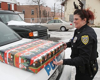 William D. Lewis The Vindicator YPD Community Police officer Shawna-Cie Ott loads gifts into a cruiser Dec 22, 2016.Community police officers donated and delivered Christmas gifts to several families