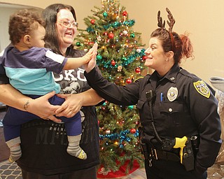 William D. Lewis The Vindicator YPD Community Police offocer Shawna-Cie Ott hi fives Zavery Hawthorne, 13 months and his mother  Ann MArino holds him in their West side Youngstown home Dec 22, 2016. They were one of several homes where community police officers donated and delivered Christmas gifts.