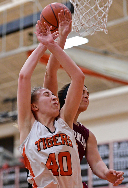 HOWLAND, OHIO - DECEMBER 23, 2016: Kayla Clark #40 of Howland loses control of the rebound while being bumped from behind by Lauren Gabriele #20 of Boardman during the second half of their game Friday night at Howland High School. DAVID DERMER | THE VINDICATOR