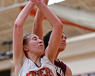 HOWLAND, OHIO - DECEMBER 23, 2016: Kayla Clark #40 of Howland loses control of the rebound while being bumped from behind by Lauren Gabriele #20 of Boardman during the second half of their game Friday night at Howland High School. DAVID DERMER | THE VINDICATOR